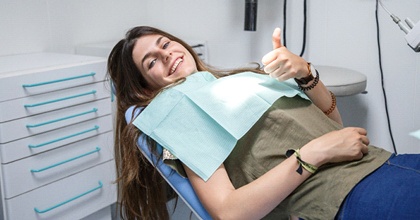 woman reclined in dental chair smiling after gum disease treatment