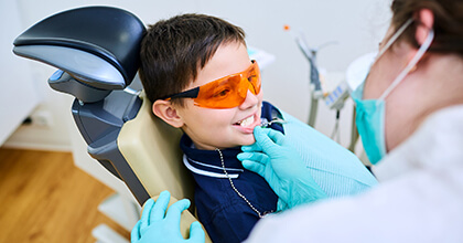 Young boy with protective glasses receives dental sealants