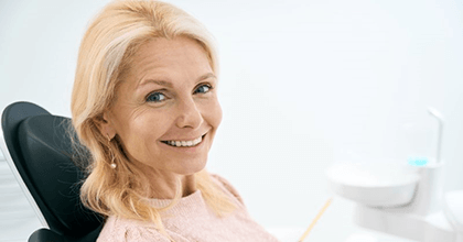 a patient smiling after completing her dental implant treatment