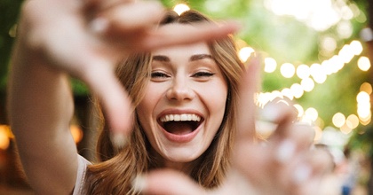 Smiling woman framing her face with her fingers