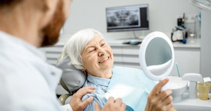  a patient smiling after paying for dentures in Bristol