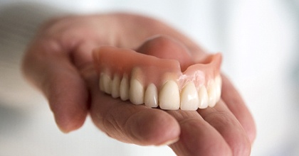 hand holding denture