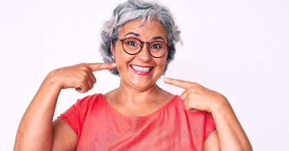 Happy senior woman enjoying the benefits of implant dentures