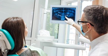 dentist showing a patient X-rays of their mouth
