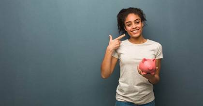 woman with a piggy bank pointing to her smile 