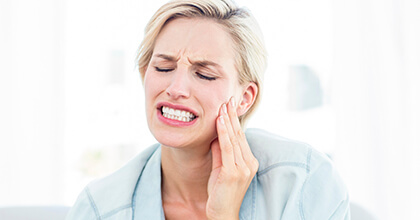 Woman in pain holding cheek