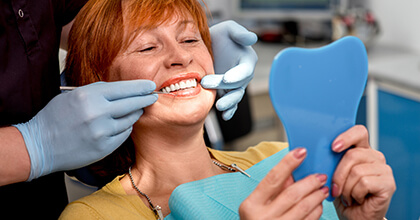 Dentist and patient examine smile in mirror