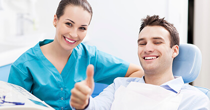 Man in dental chair giving thumbs up