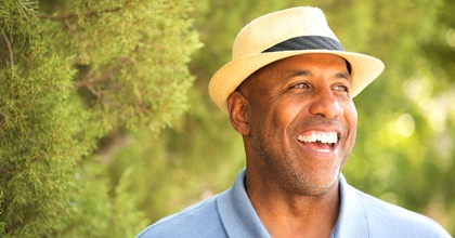 older man in blue polo and fedora smiling with veneers in Bristol 