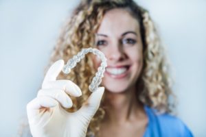 dentist holding clear aligner