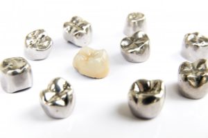 one ceramic dental crown among several metal crowns 