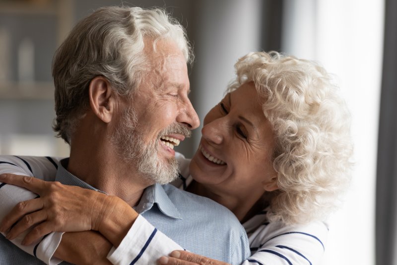 mature couple smiling with implant dentures
