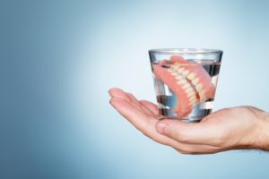 dentures being soaked after being removed from someone's mouth