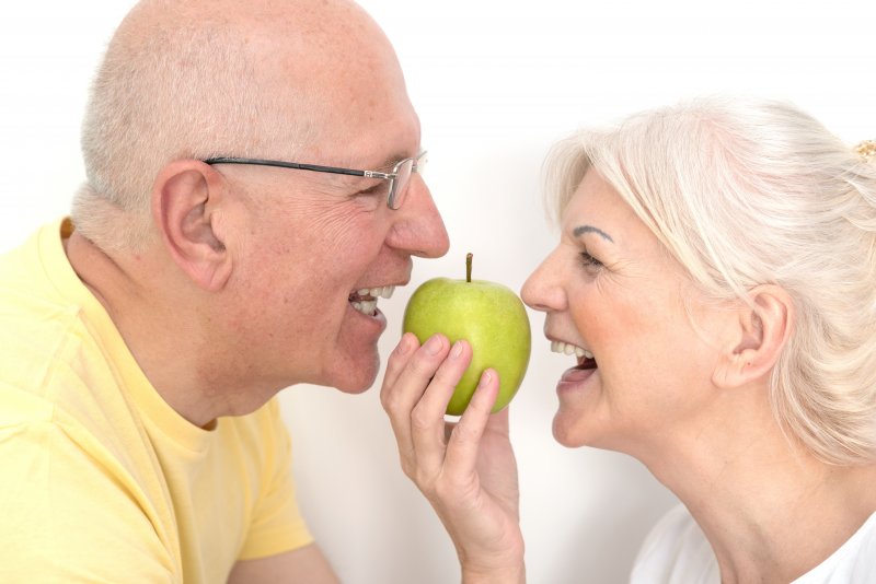 A couple with dentures about to share an apple