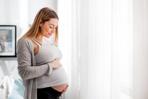 Pregnant woman holding belly. 